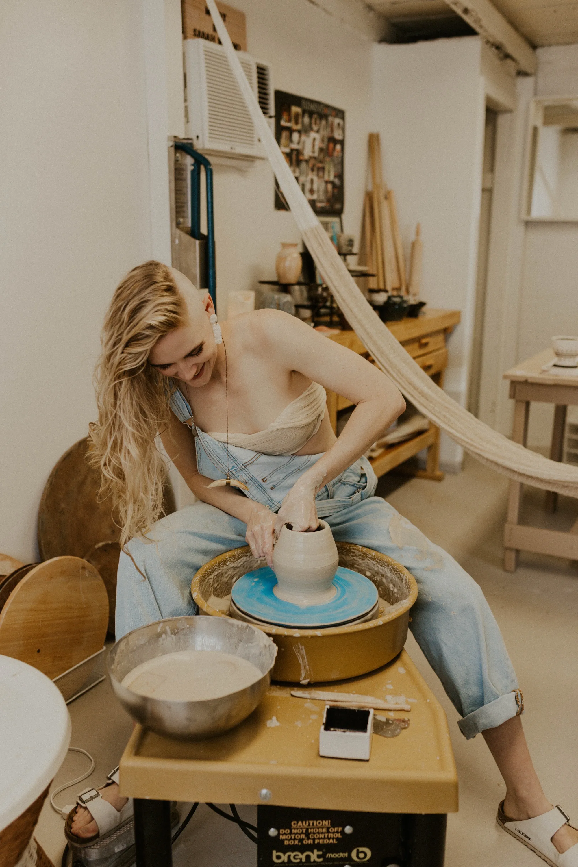 Sarah at the wheel, smiling while throwing