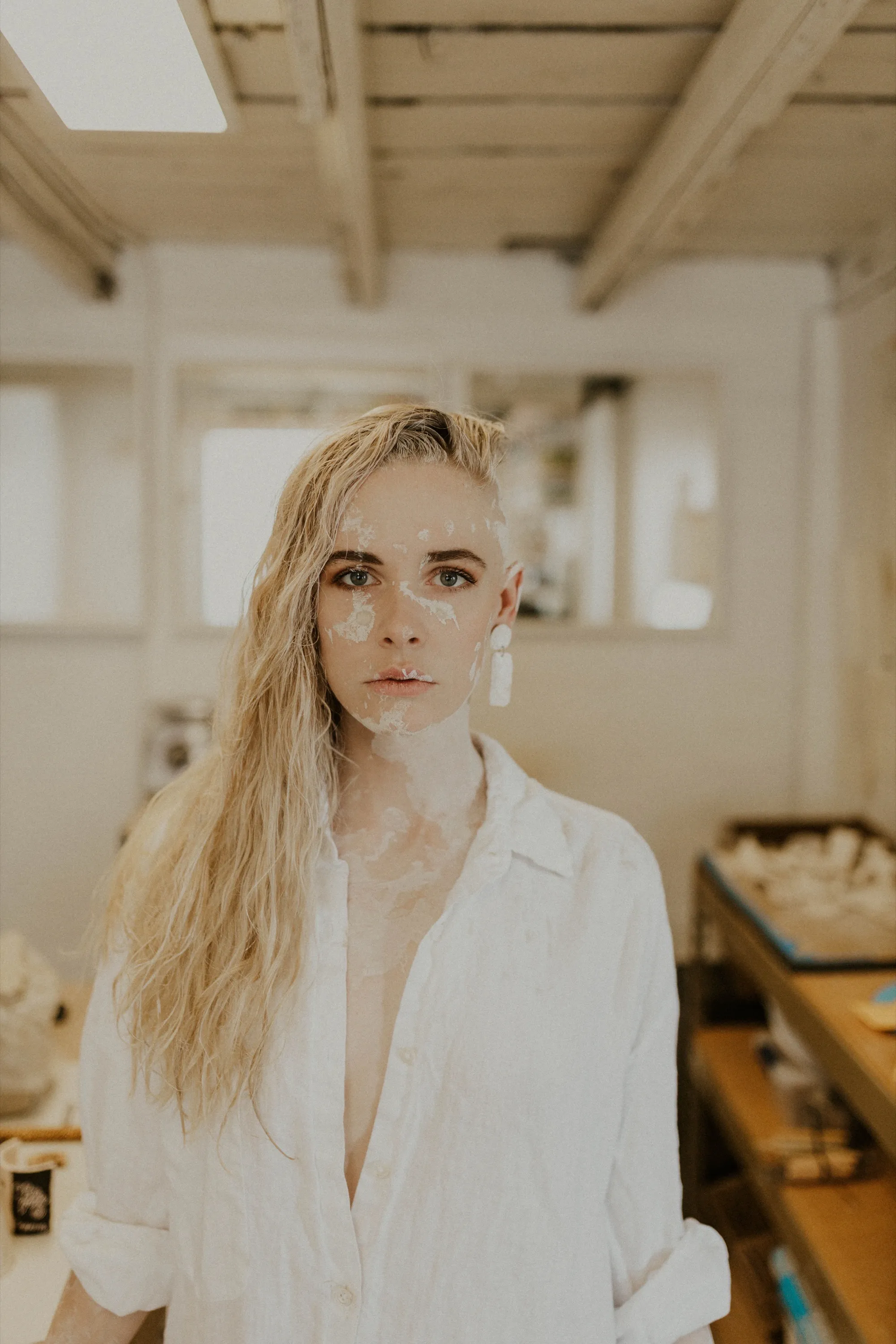 Sarah Marino in her ceramics studio, clay on face